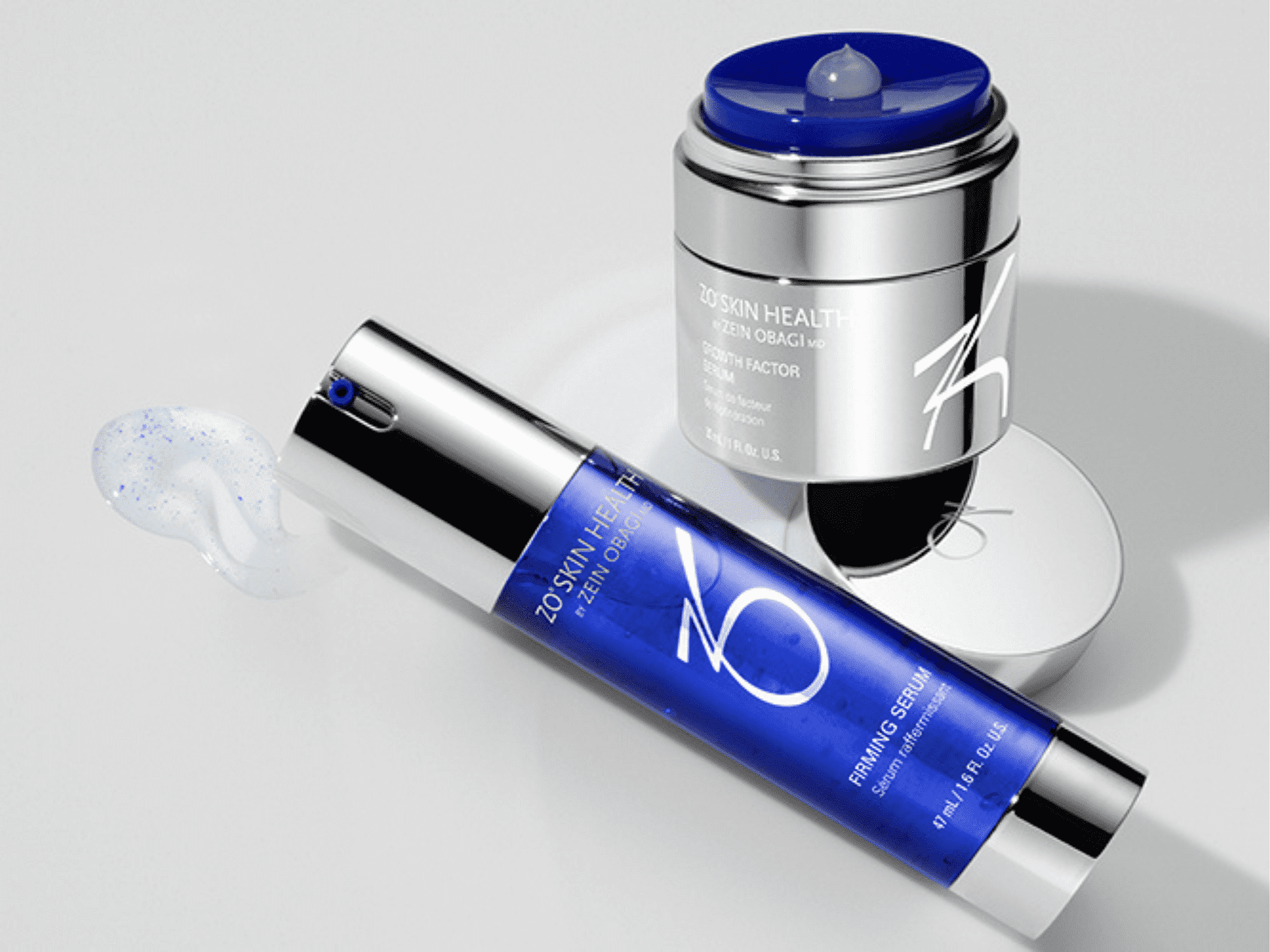 Anti-aging skincare products with firming serum and cream in sleek blue and silver packaging.