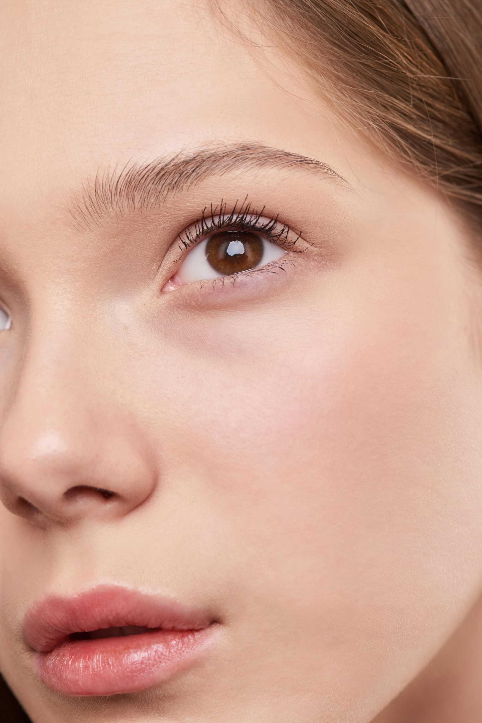Close-up of a woman's eye and face, highlighting smooth skin and natural beauty.